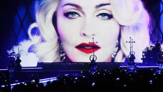 Tänzer tragen am 10.11.2015 in der Mercedes-Benz-Arena in Berlin zu Beginn eines Konzertes der US-amerikanischen Popsängerin Madonna Kreuze über die Bühne. (Quelle: dpa)